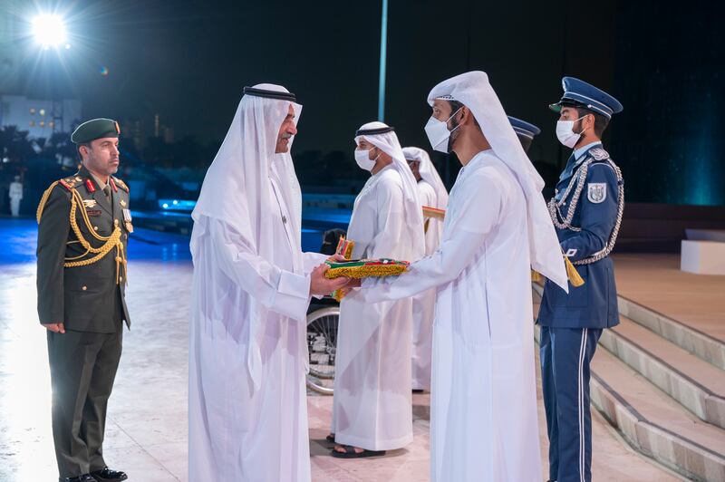 Sheikh Hamad bin Mohammed Al Sharqi, Ruler of Fujairah, presents a medal to a relative of a UAE hero who died this year, at Wahat Al Karama. Photo: Mohamed Al Hammadi / Ministry of Presidential Affairs