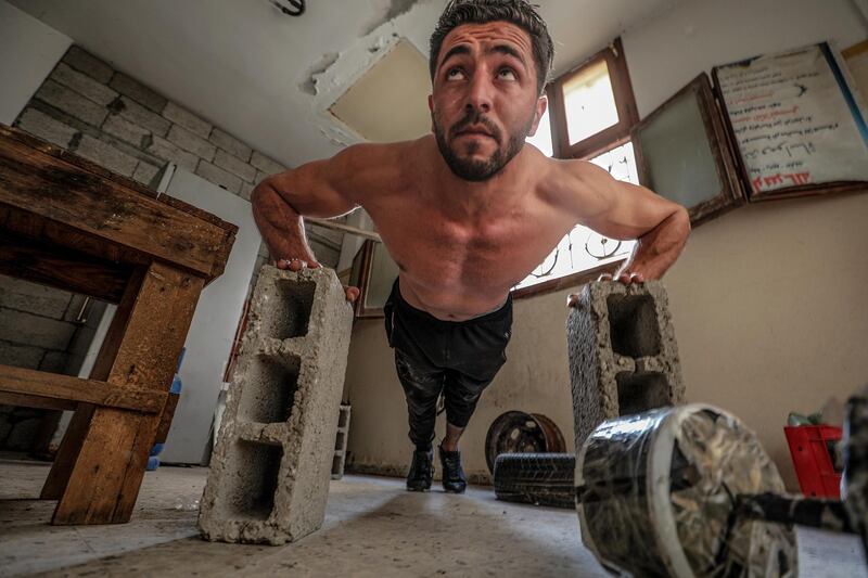 Palestinian bodybuilder Ahmed Tlatini, aged 26, trains at his home in Gaza City.  EPA