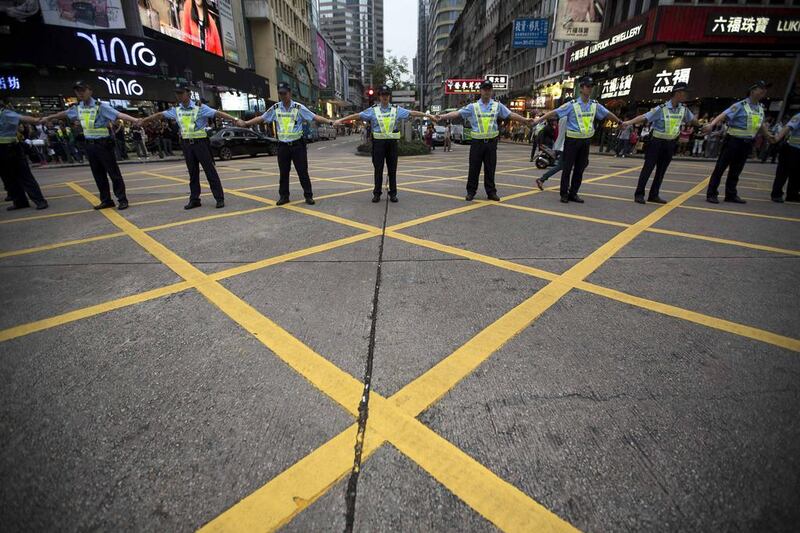 Police officers form a barrier blocking a main road as croupiers and casino employees march on the street to demand better working condition and against migrant workers from mainland China and other countries, during International Labour Day in Macau. Tyrone Siu / Reuters