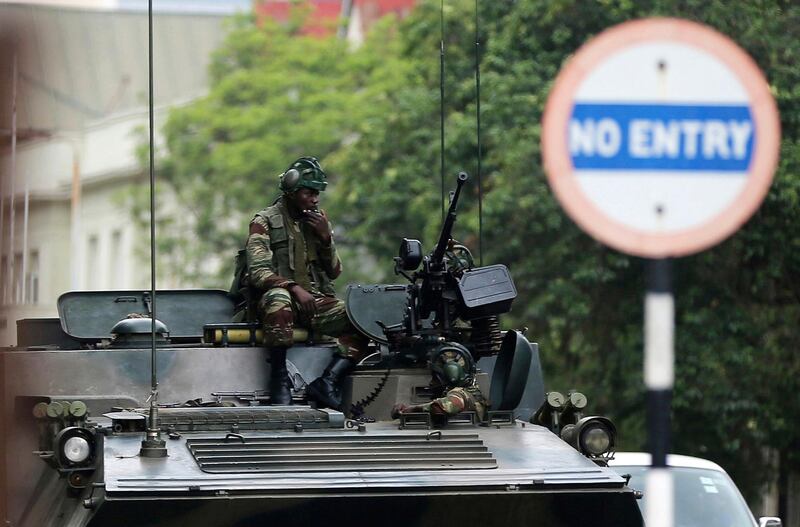 Soldiers sit on a military vehicle parked on a street in Harare, Zimbabwe, Thursday, Nov. 16, 2017. People across the country are starting another day of uncertainty amid quiet talks to resolve the country's political turmoil and the likely end of President Robert Mugabe's decades-long rule. Mugabe has been in military custody and there is no sign of the recently fired deputy Emmerson Mnangagwa, who fled the country last week. (AP Photo)