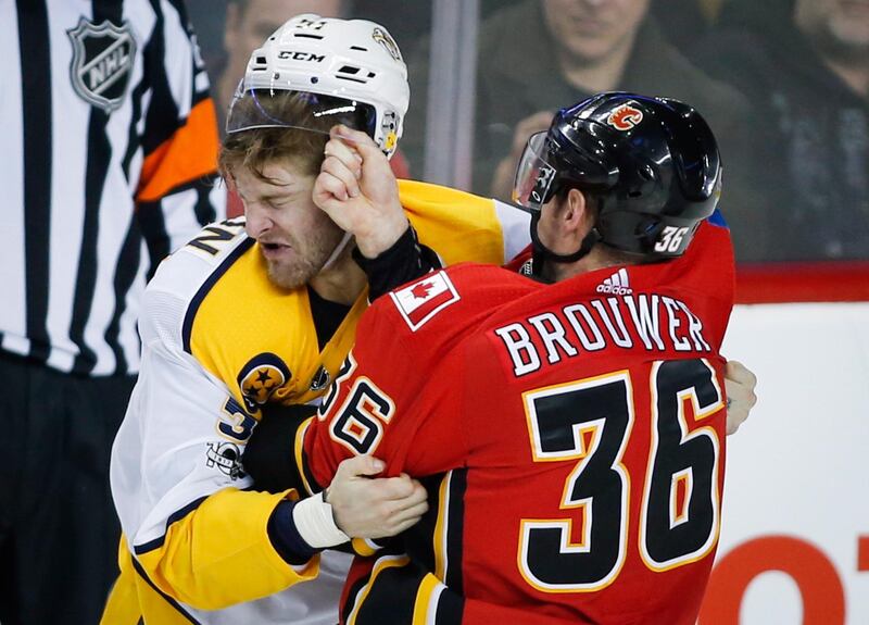 Nashville Predators' Austin Watson fights with Calgary Flames' Troy Brouwer during the second period of an NHL hockey game in Calgary, Alberta. Jeff McIntosh / The Canadian Press via AP