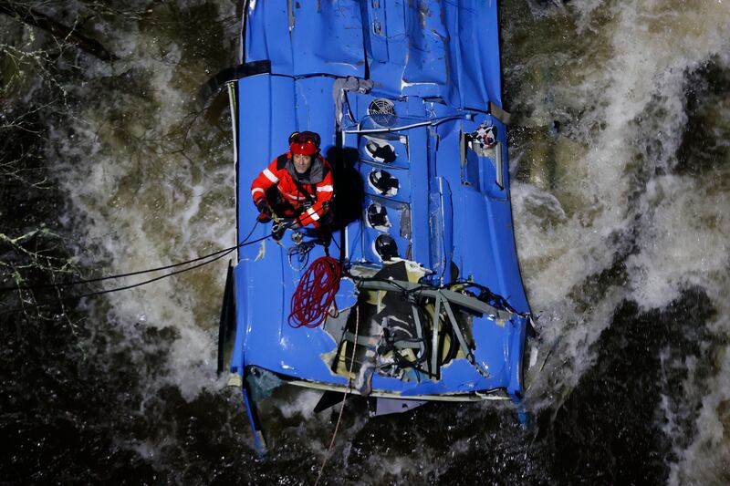 A fireman works to rescue victims of a bus that fell into Lerez river in Cerdedo-Cotobade, Pontevedra, in the province of Galicia, Spain 25 December 2022.  The bus, coming from the prison of Monterroso in Lugo, plunged into the water after getting off the road while crossing a bridge.  Two people died and three other are missing.   EPA / LAVANDEIRA JR