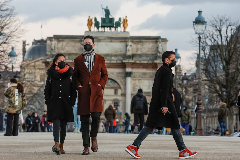 People wearing protective face masks walk in the Tuileries Gardens in Paris as infections soar to record levels. Reuters
