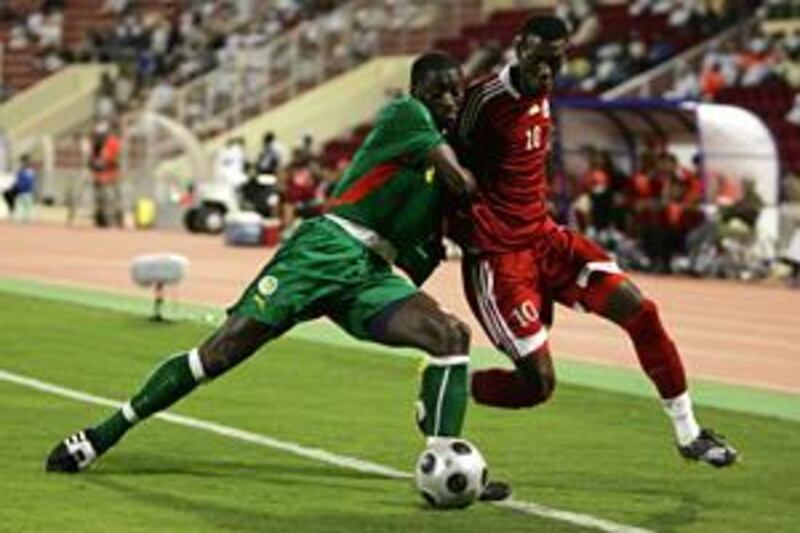 Oman's creative midfielder Fawzi Bashir, right, fights for the ball with Mohammed Coly of Senegal during their friendly in Muscat on Dec 22.