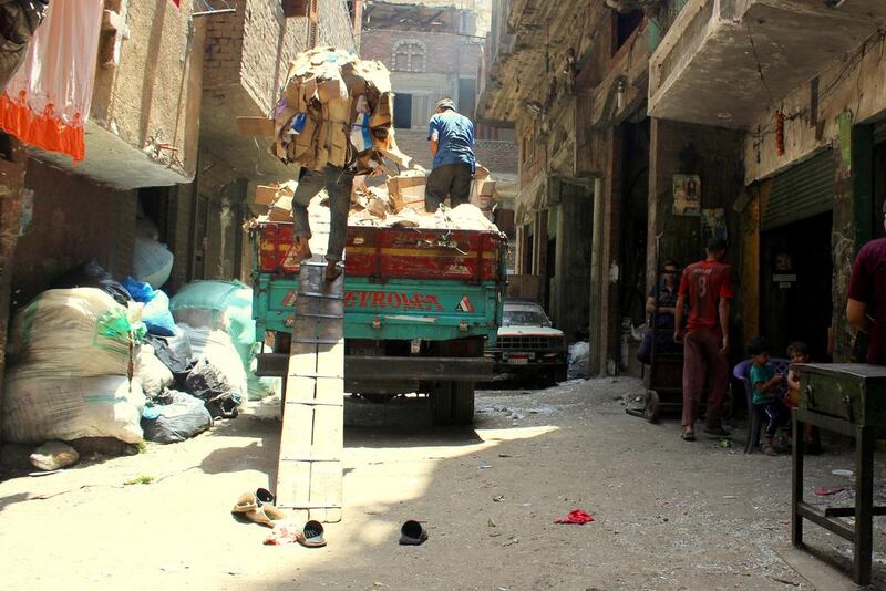 Coptic Christian men in the Manshiyat Naser neighbourhood packing garbage on a truck to sell in Cairo. Sandor Jaszberenyi / The National