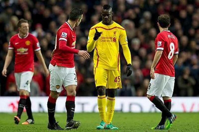 Liverpool's Mario Balotelli, centre, gestures to Manchester United's Robin van Persie during the English Premier League football match at Old Trafford Stadium, Manchester, England, Sunday Dec. 14, 2014. (AP Photo/Jon Super)