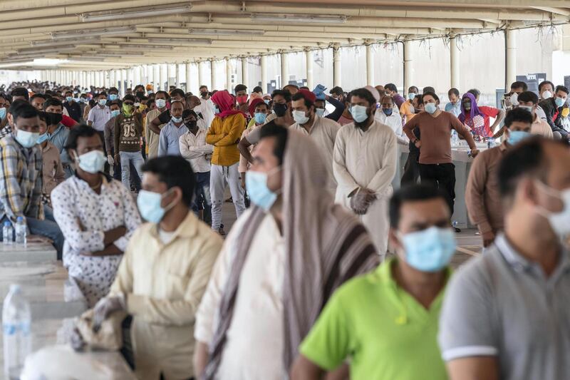 ABU DHABI, UNITED ARAB EMIRATES. 16 APRIL 2020. COVID-19 Testing station in Al Mussafah. Men wait in line for their pre-check ahead of being tested. (Photo: Antonie Robertson/The National) Journalist: Haneen Dajani. Section: National.