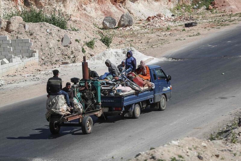 Residents flee with their belongings from reported regime shelling on the southern countryside of the extremist-held Idlib province.  AFP