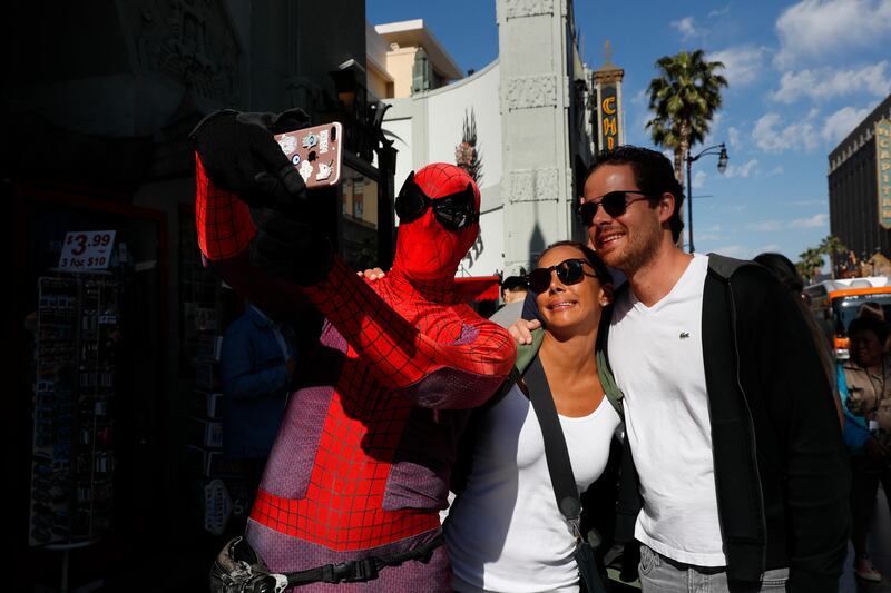 Superhero impersonator and actor Dan Inigo, left, uses a tourist's smartphone to take a selfie on Hollywood Boulevard in Los Angeles. "It's a place of diversity, it's a place of drama, it's a place of illusion … a place of broken dreams," says the 25-year-old actor who prowls the boulevard dressed as Spider-Man. Although he barely scrapes by, Inigo says it's still a great gig for a struggling actor who needs to keep a schedule open for auditions. Jae C Hong / AP Photo