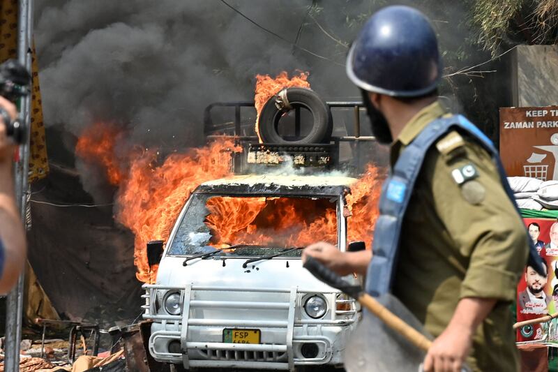 A van burns during clashes between supporters of former Pakistani prime minister Imran Khan and riot police near Khan's house to prevent officers from arresting him, in Lahore. AFP