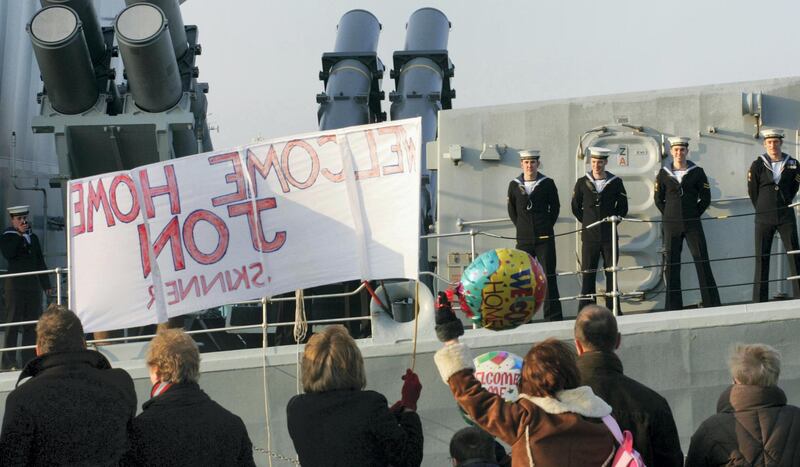 Family members wave to loved ones aboard the Royal Navy frigate HMS Richmond as she returns home to Portsmouth for Christmas today after an eventful seven-month security mission in the Arabian Gulf.   (Photo by Chris Ison - PA Images/PA Images via Getty Images)