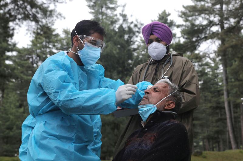 Health workers collect a nasal swab sample from a man for Covid-19 testing at Khag village, in central Kashmir's Budgam district. AFP