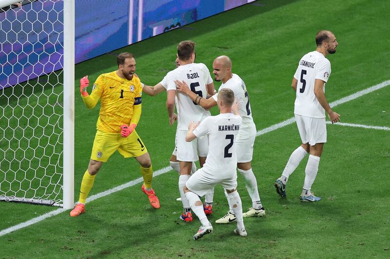 Jan Oblak of Slovenia celebrates with teammates after saving a penalty kick from Cristiano Ronaldo. Getty Images