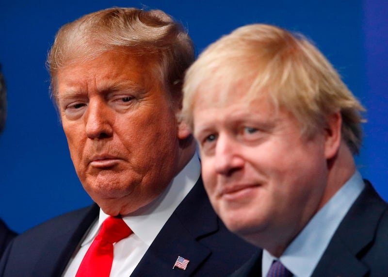 TOPSHOT - Britain's Prime Minister Boris Johnson (R) welcomes US President Donald Trump (L) to the NATO summit at the Grove hotel in Watford, northeast of London on December 4, 2019. / AFP / POOL / PETER NICHOLLS
