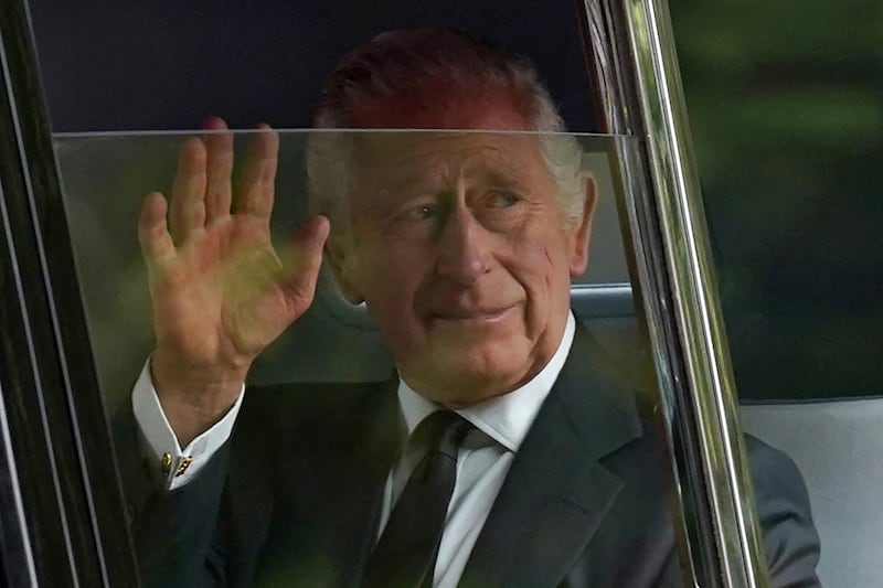 King Charles waves to the crowds after leaving Clarence House in central London, before the procession. AFP