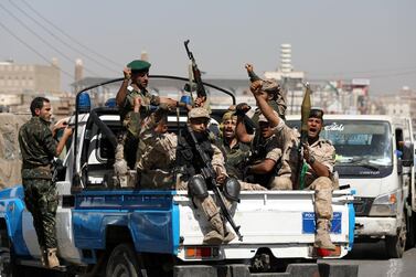Houthi fighters ride on the back of a police patrol truck in Sanaa. Reuters