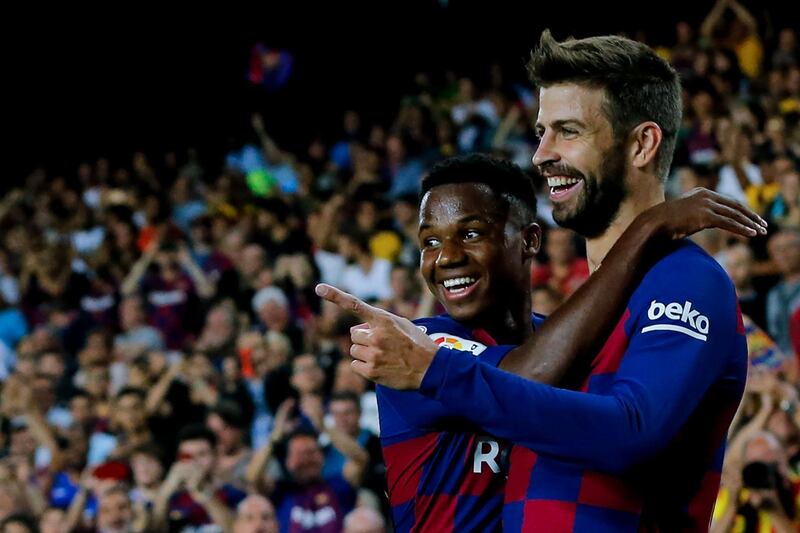 Barcelona's Spanish defender Gerard Pique is congratulated by teammate Ansu Fati after scoring to give Barca a 3-1 lead against Valencia. EPA