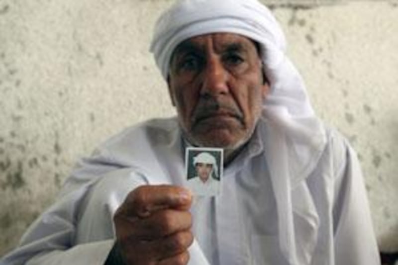 Mohammed Hassan holds up a photo of his son Ali Hassan who was stabbed to death on Thursday night.