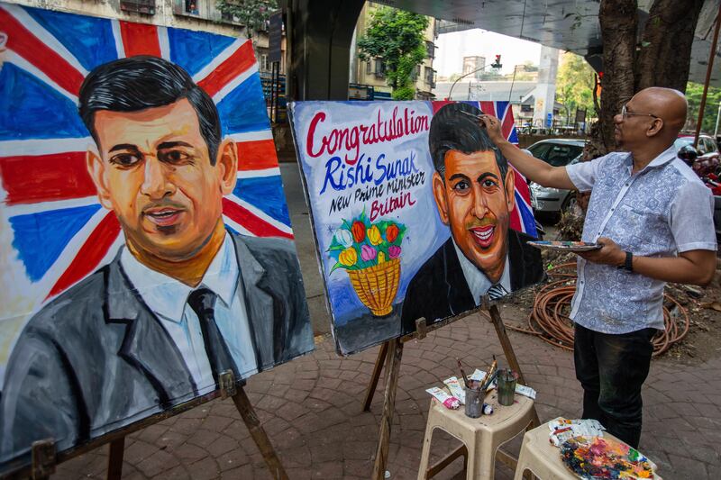 An Indian artist in Mumbai creates a painting to congratulate Mr Sunak on becoming prime minister. EPA