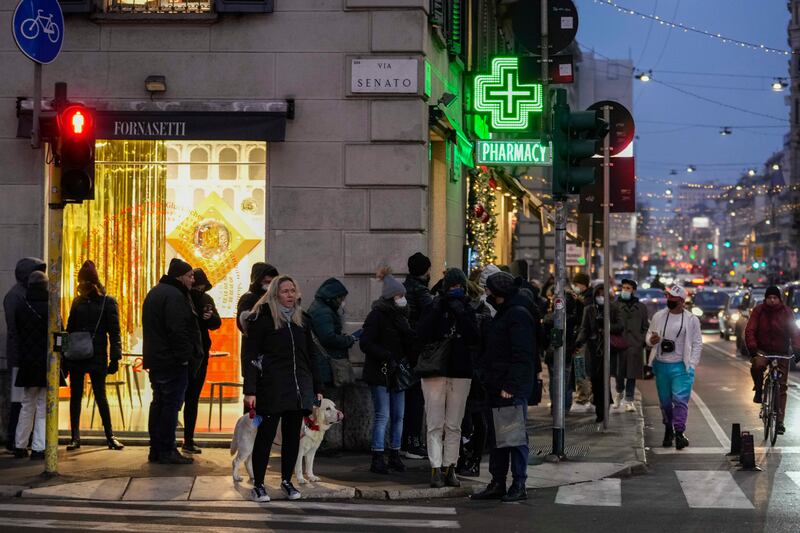 People line up outside a pharmacy for Covid-19 swab tests in Milan. AP.