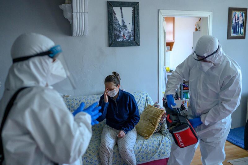 TOPSHOT - Health workers help a woman who tested positive for the novel coronavirus COVID-19,  at Bagcilar in Istanbul, on April 28, 2019, in Istanbul. / AFP / Bulent Kilic
