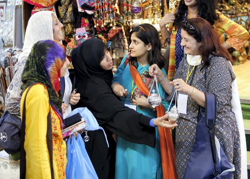 Women look at items at a market on March 18, 2015 in the Omani capital, Muscat.   AFP PHOTO / MOHAMMED MAHJOUB (Photo by MOHAMMED MAHJOUB / AFP)