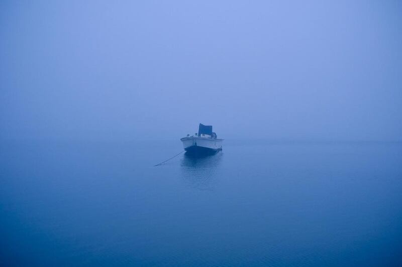 A fishing boat moored off the coast of Umm Al Quwain sits suspended in the morning fog on March 10, 2014. Antonie Robertson / The National
