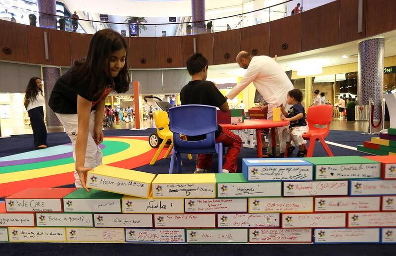 Humza Chaudhry donated a brick to build a wall at Dubai Mall in support of one of Dubai Cares’ many charity projects. Pawan Singh / The National