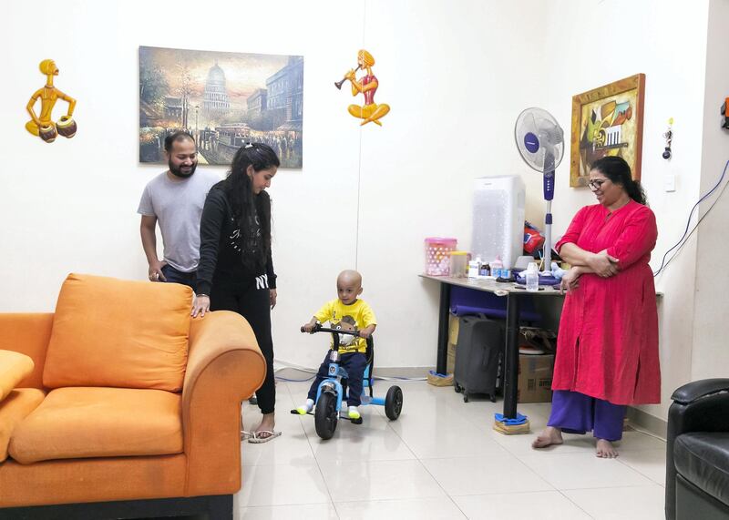 DUBAI, UNITED ARAB EMIRATES. 19 APRIL 2020. 
Aarev Shetty, 2, rides his tricylce. He just returned from the hospital after receiving his cancer treatment. His dad, Sushant Shetty, mom, Anu Rai, and grandmother, Shakuntala Shetty stand by him. (Photo: Reem Mohammed/The National)

Reporter:
Section: