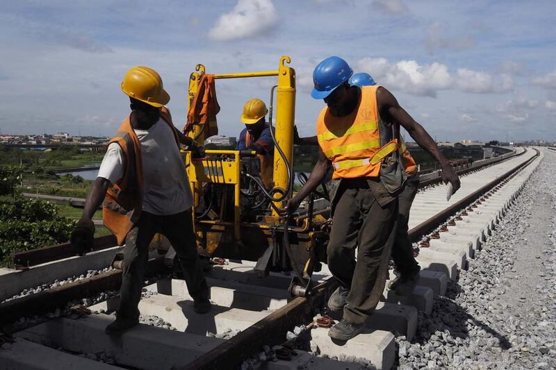 Men work on a train track of the Blue Line of the light rail system under construction in Lagos, Nigeria. The Blue Line costs $1.2 billion and is funded entirely by the Lagos state government. Joe Penney / Reuters
