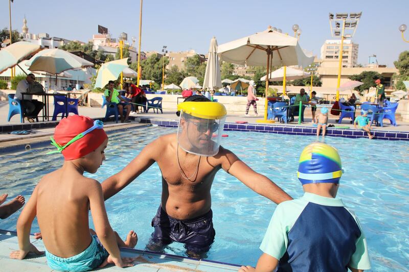 Coaches wear face shields during swimming classes at a sporting club in Cairo, Egypt.  EPA