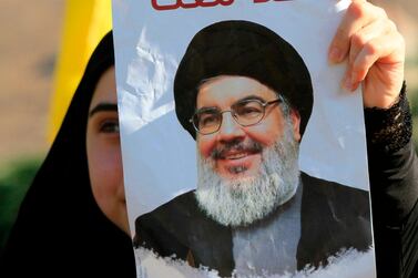 A supporter of Hezbollah holds a poster bearing a picture of its leader Hasan Nasrallah. AFP