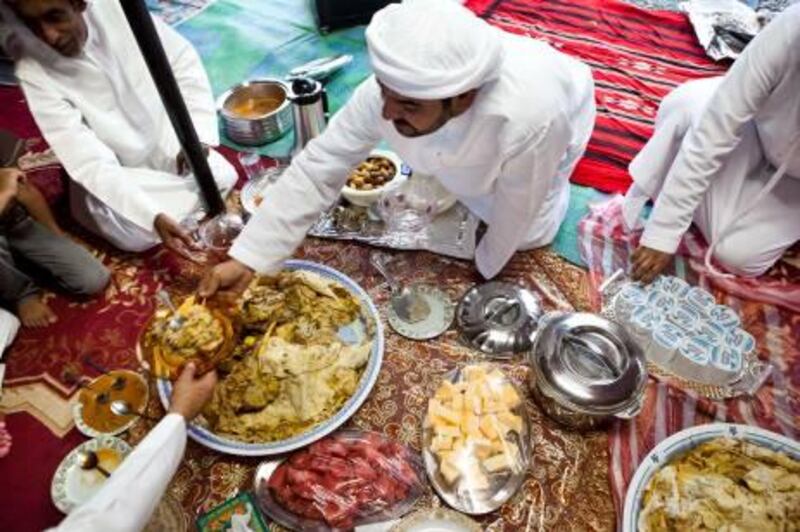 :JuAbdullah Al Yalyle dishes up a traditional meal at his home majlis in Wadi al Tuwa, Ras al Khaimah.