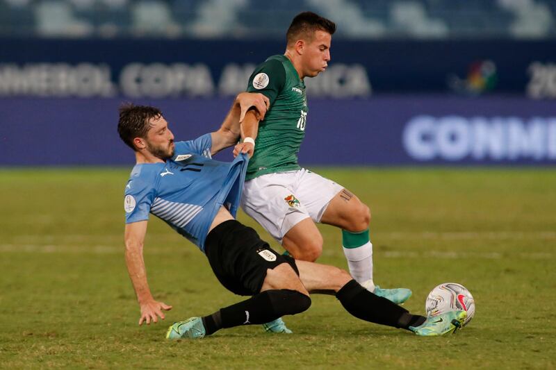 Uruguay's Matias Vina makes a slide tackle on Bolivia's Henry Vaca. Getty
