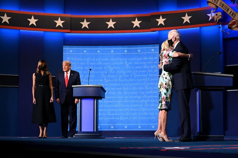 (FILES) In this file photo taken on October 22, 2020, US First Lady Melania Trump (L) stands with US President Donald Trump as Jill Biden (R) hugs husband Democratic Presidential candidate Joe Biden at the end of the final presidential debate at Belmont University in Nashville, Tennessee. Jill Biden is no stranger to the glare of the political spotlight. Her husband has been a Washington insider since they wed in 1977, and she was America's second lady for eight years. But if Joe Biden wins the White House, his 69-year-old wife will have the opportunity to push the role of first lady into the 21st century -- by keeping her full-time job as a professor. "Most American women have both a work life and a family life, but first ladies have never been allowed to do so," said Katherine Jellison, a history professor at Ohio University. / AFP / Jim WATSON
