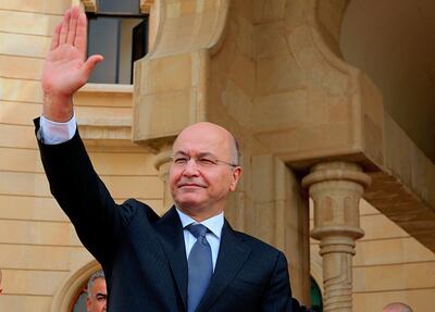 FILE - In this Oct. 11, 2018 file photo, Iraqi President Barham Salih waves goodbye to Turkish Foreign Minister Mevlut Cavusoglu, after their meeting in Baghdad, Iraq. Salih speaking Monday, Feb. 4, 2019, at a forum in Baghdad slammed comments by U.S. President Donald Trump in which he said he wants to keep U.S. troops in Iraq "to watch Iran." Salih said the U.S. president did not ask Iraq's permission for American troops stationed there to watch Iran. He said the Iraqi constitution forbids the use of Iraq as a base to threaten the interests or security of neighboring countries. (AP Photo/Karim Kadim, File)