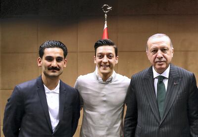 (ALTERNATIVE CROP) This handout picture taken on May 13, 2018 and released on May 14, 2018 by the Turkish Presidential Press office shows Turkish President Recep Tayyip Erdogan(R) posing for a photo with German footballers of Turkish origin Ilkay Gundogan (L) and Mesut Ozil (2nd L) in London. / AFP PHOTO / TURKISH PRESIDENTIAL PRESS SERVICE / KAYHAN OZER / RESTRICTED TO EDITORIAL USE - MANDATORY CREDIT "AFP PHOTO / TURKISH PRESIDENTIAL PRESS OFFICE / KAYHAN OZER" - NO MARKETING NO ADVERTISING CAMPAIGNS - DISTRIBUTED AS A SERVICE TO CLIENTS - ALTERNATIVE CROP / TO GO WITH SID STORY by Marco MADER and Oliver MUCHA on June 10, 2018