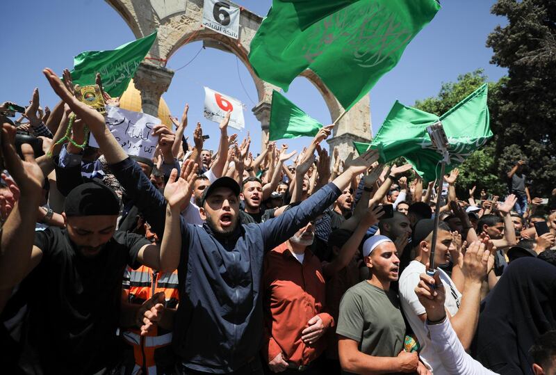 People hold Hamas flags as Palestinians gather after the last Friday prayers of Ramadan to protest over the possible eviction of several Palestinian families from homes on land claimed by Jewish settlers in the Sheikh Jarrah neighbourhood, in Jerusalem's Old City. Reuters