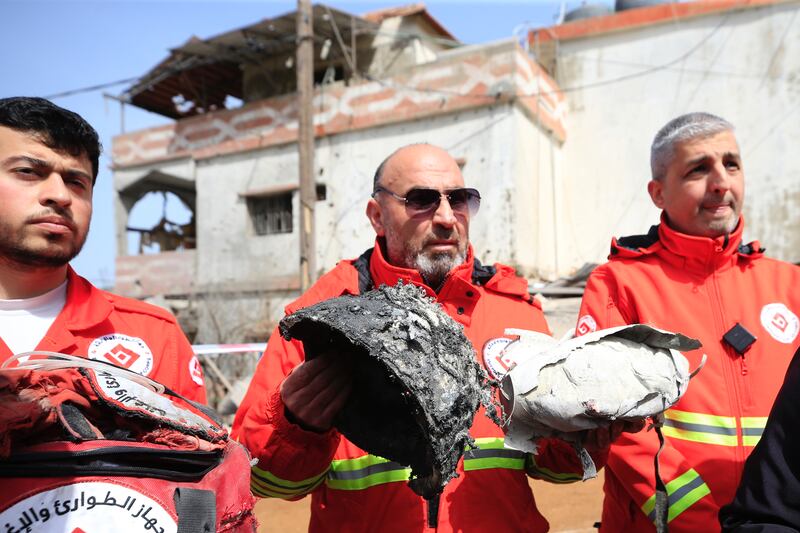 Rescuers show belongings of victims at the site of an Israeli air strike in Habariyeh, southern Lebanon, in March. EPA