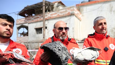 Rescuers show belongings of victims at the site of an Israeli air strike in Habariyeh, southern Lebanon, in March. EPA