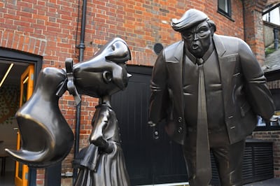 A sculpture of Roald Dahl character Matilda (L) is seen next to one of US President Donald Trump at the newly renovated Roald Dahl Museum and Story Centre in Great Missenden, north-west of London, England on October 16, 2018. From a dingy and macabre hut tucked away in the English countryside, author Roald Dahl dreamed up worlds that have enchanted youngsters across the globe. Stuffed with hundreds of weird and wonderful mementos, the garden hut was where the cherished children's novelist sat in a battered armchair and wrote his fantastical tales. A museum including a replica of the hut in the same village of Great Missenden where Dahl lived reopens to the public on Saturday following an extensive renovation triggered by a flash flood. / AFP / Robin MILLARD
