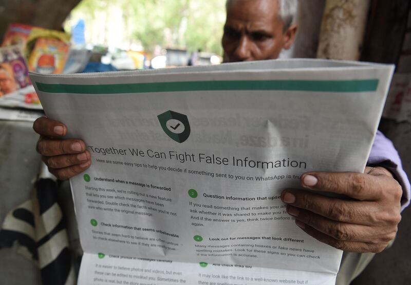 (FILES) In this file photo illustration taken on July 10, 2018 shows an Indian newspaper vendor reading a newspaper with a full back page advertisement from WhatsApp intended to counter fake information, in New Delhi. A deluge of online hoaxes that hit Indian social media as the country fought aerial battles with neighbouring Pakistan has heightened fears over the "fake news" war looming in India's national election.
 / AFP / Prakash SINGH / To go with INDIA-POLITICS-MEDIA-INTERNET-NEWS,FOCUS by Uzair Rizvi and Katie Forster
