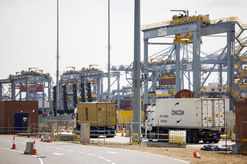Lorries carrying shipping containers are driven across the dockside at London Gateway port, operated by DP World Plc, in Stanford-le-Hope