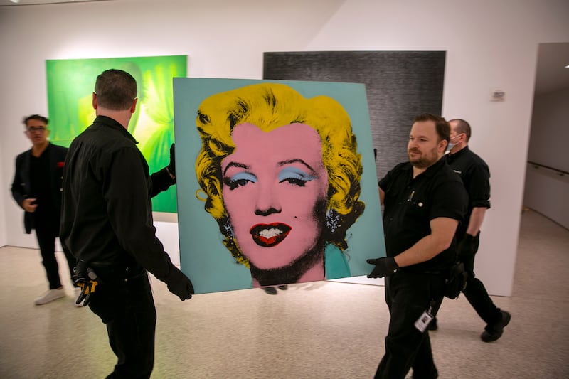 The 1964 painting 'Shot Sage Blue Marilyn' by Andy Warhol is carried in Christie's showroom in New York City, New York. AP