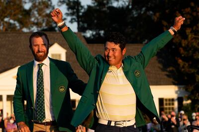 FILE - In this Sunday, April 11, 2021 file photo, Hideki Matsuyama, of Japan, puts on the champion's green jacket after winning the Masters golf tournament as Dustin Johnson watches in Augusta, Ga. Matsuyama already is thinking about what to serve at the champions dinner next April. It likely will include sushi. (AP Photo/David J. Phillip, File)