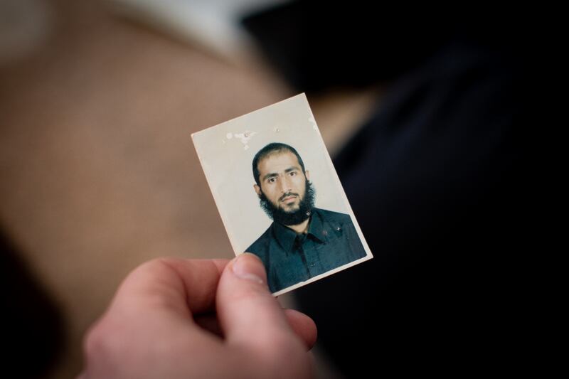 Ibrahim Al Shawakh looks at a photo of his nephew Ali Moussa, also known as Abu Luqman, in his home on the outskirts of Raqqa. Tom Nicholson for The National