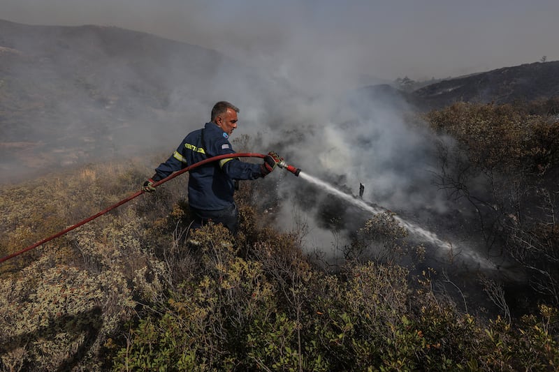 A firefighter tries to extinguish a blaze near the village of Asklipieio, on the Greek island of Rhodes. Reuters
