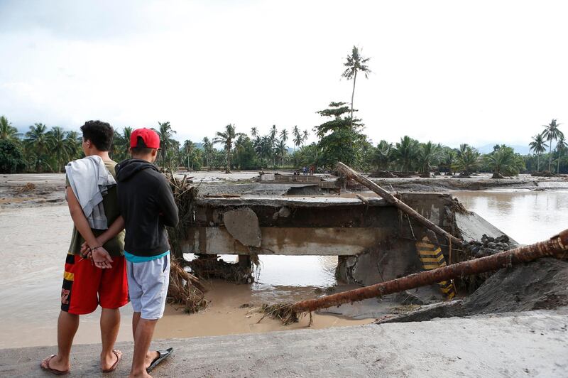 Filipino villagers view a damaged bridge in flood-hit town of Salvador, Lanao del Norte province, Philippines, on December 23, 2017. Jeoffrey Maitem / EPA