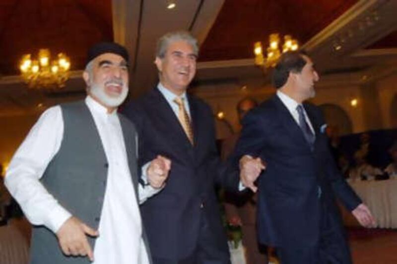 Shah Mehmoud Qureshi, the Pakistani foreign minister, centre, holding hands with Abdullah Abdullah, right, the head of the Afghan delegation and Owais Ghani, the head of the Pakistani delegation, during a jirge in Islamabad.