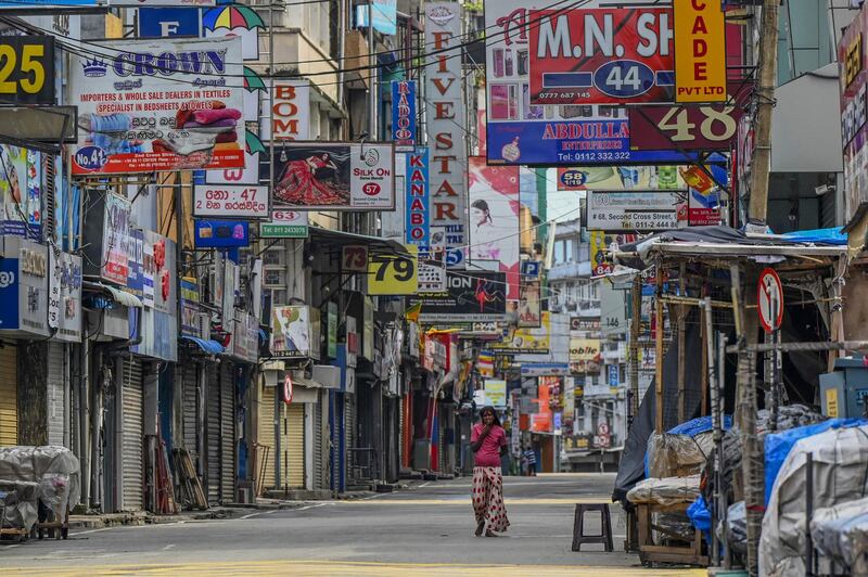 A pedestrian walks along a deserted street after the government imposed travel restrictions and a lockdown to curb the spread of the Covid-19 in Colombo, Sri Lanka. AFP